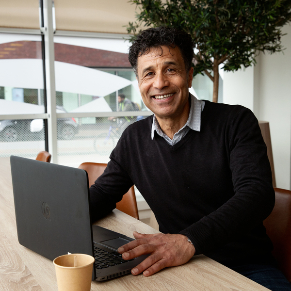 Man aan leestafel met laptop