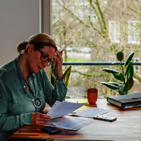 Vrouw aan tafel bezig met administratie