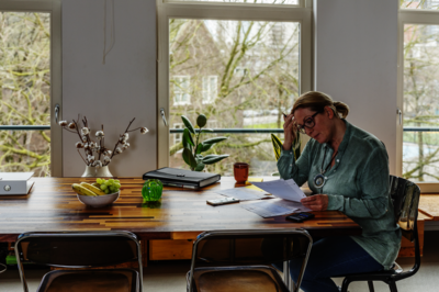 Vrouw aan tafel die administratie doet