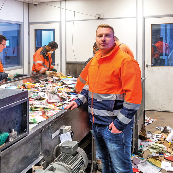 Mannen aan het werk bij afvalsorteerbedrijf